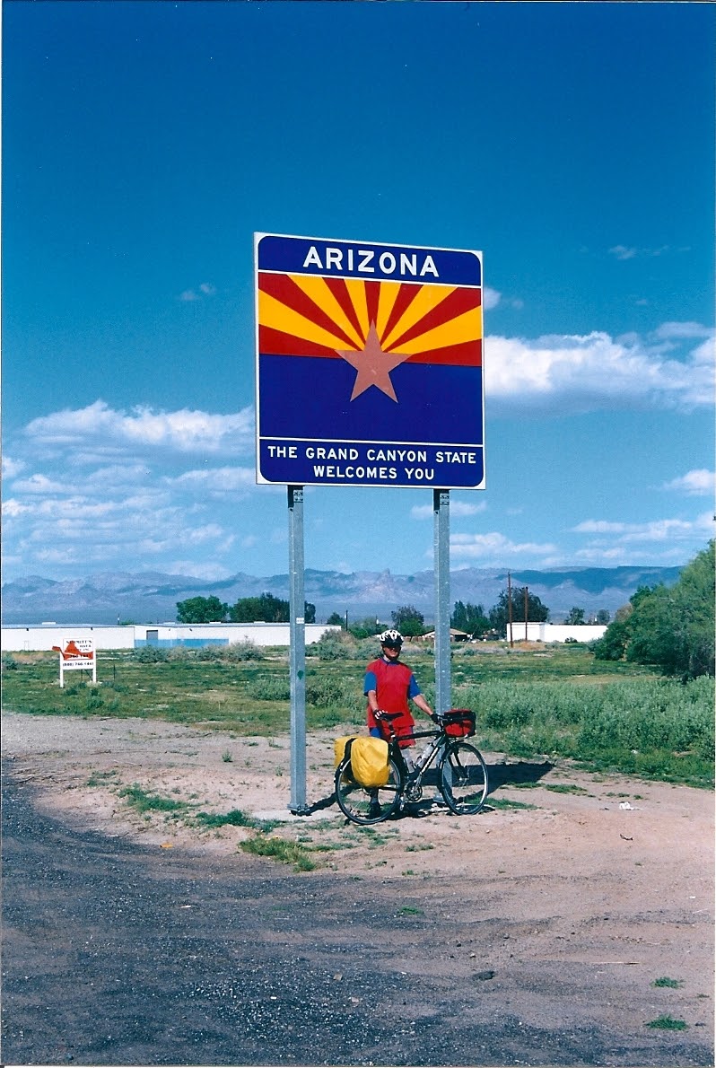 Tom or his touring bicycle photographed at the Arizona state line or state landmark.
