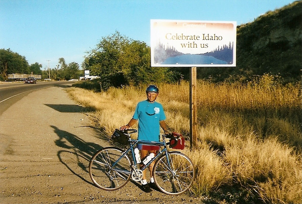 Tom or his touring bicycle photographed at the Idaho state line or state landmark.