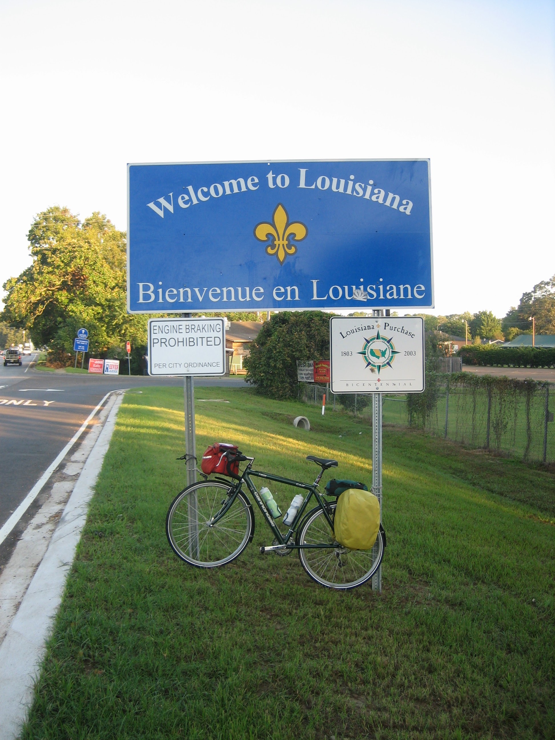 Tom or his touring bicycle photographed at the Louisiana state line or state landmark.
