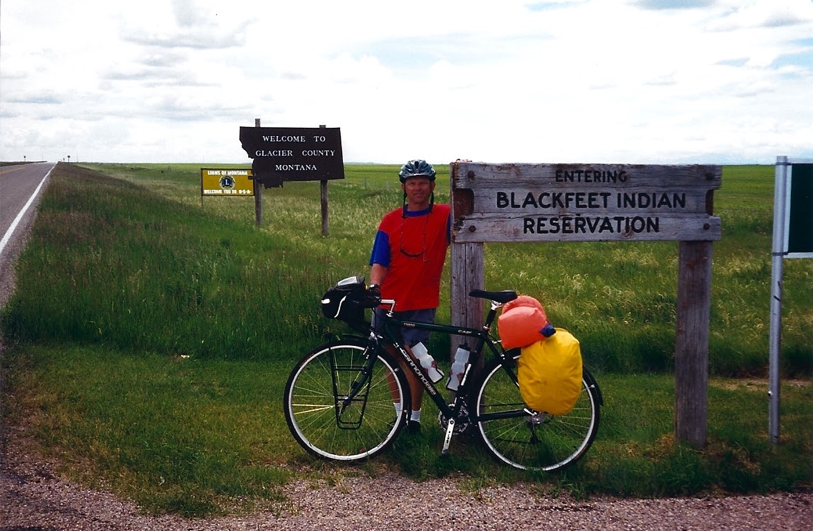 Tom or his touring bicycle photographed at the Montana state line or state landmark.