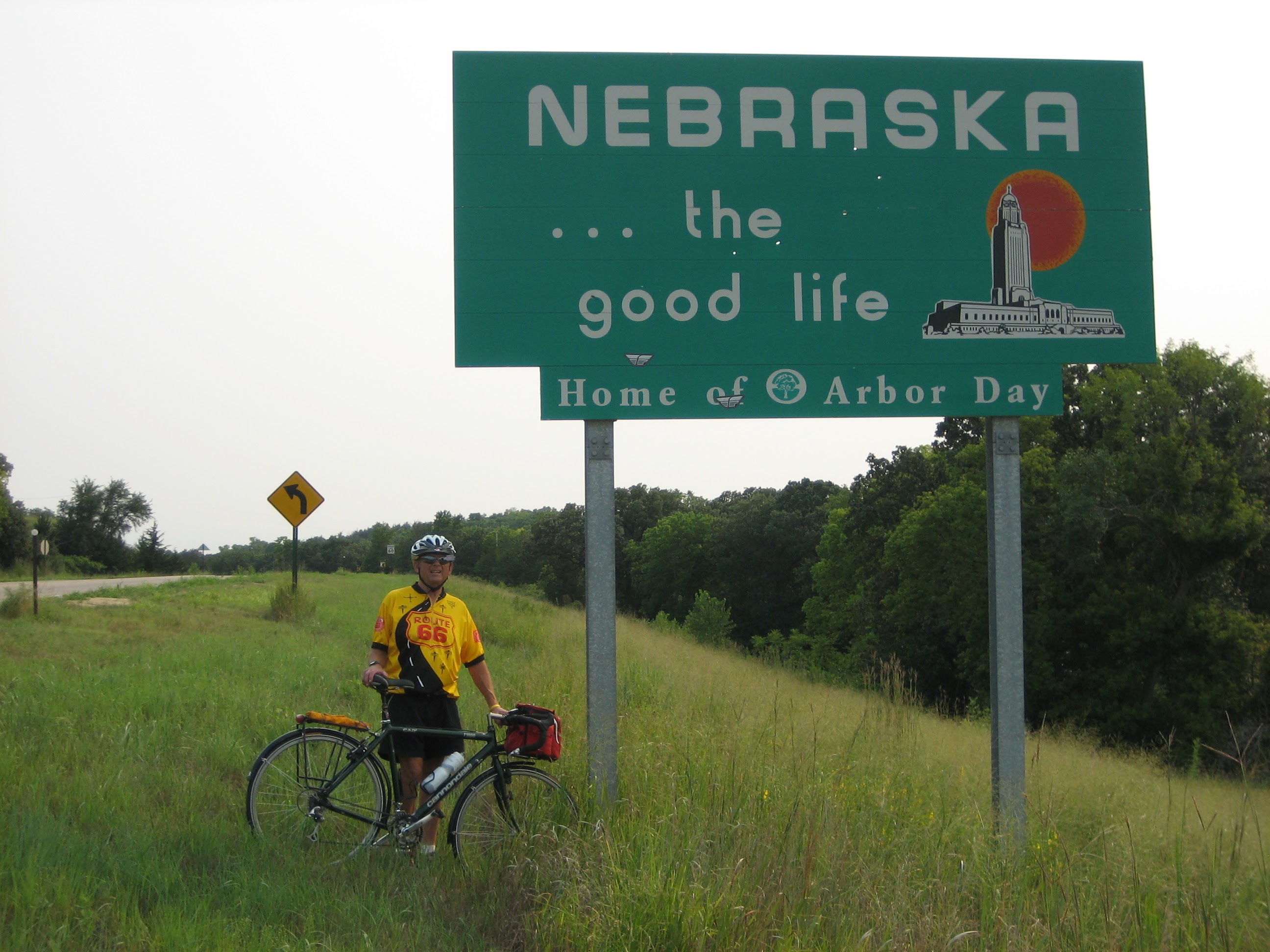 Tom or his touring bicycle photographed at the Nebraska state line or state landmark.