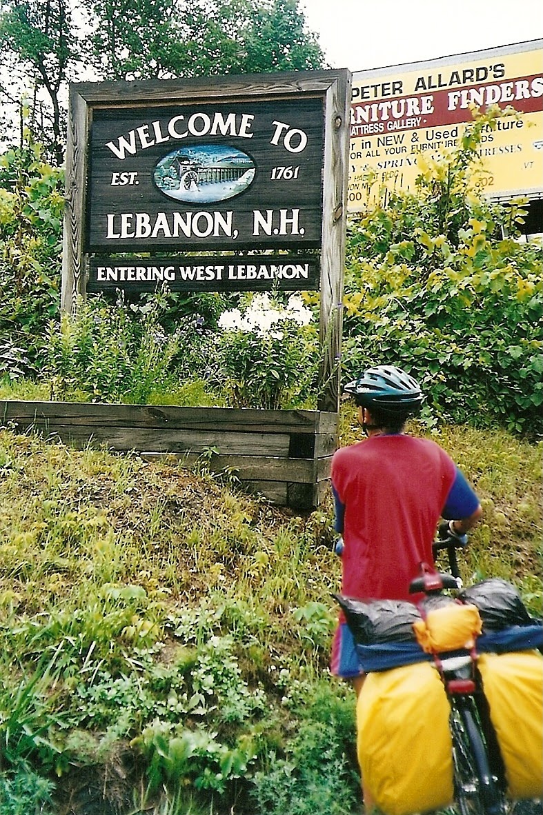Tom or his touring bicycle photographed at the New Hampshire state line or state landmark.