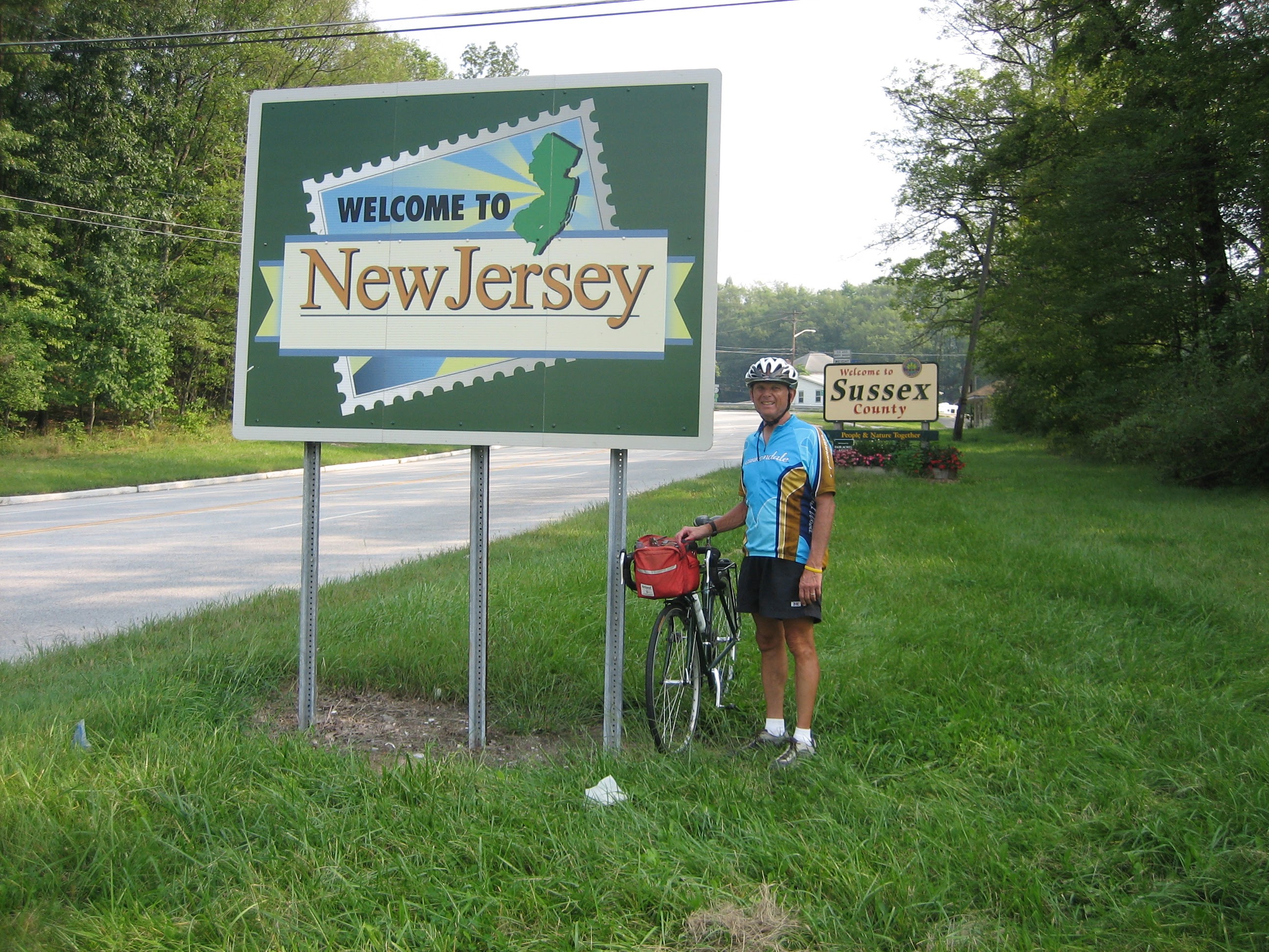 Tom or his touring bicycle photographed at the New Jersey state line or state landmark.