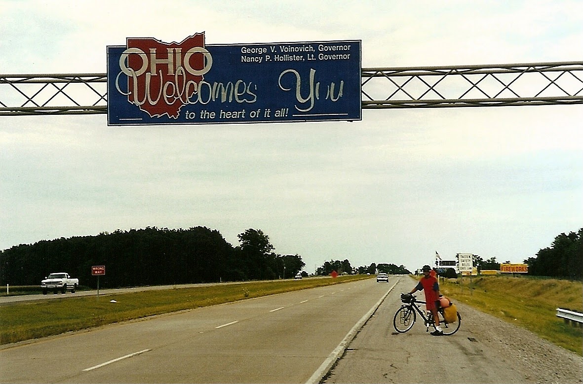 Tom or his touring bicycle photographed at the Ohio state line or state landmark.