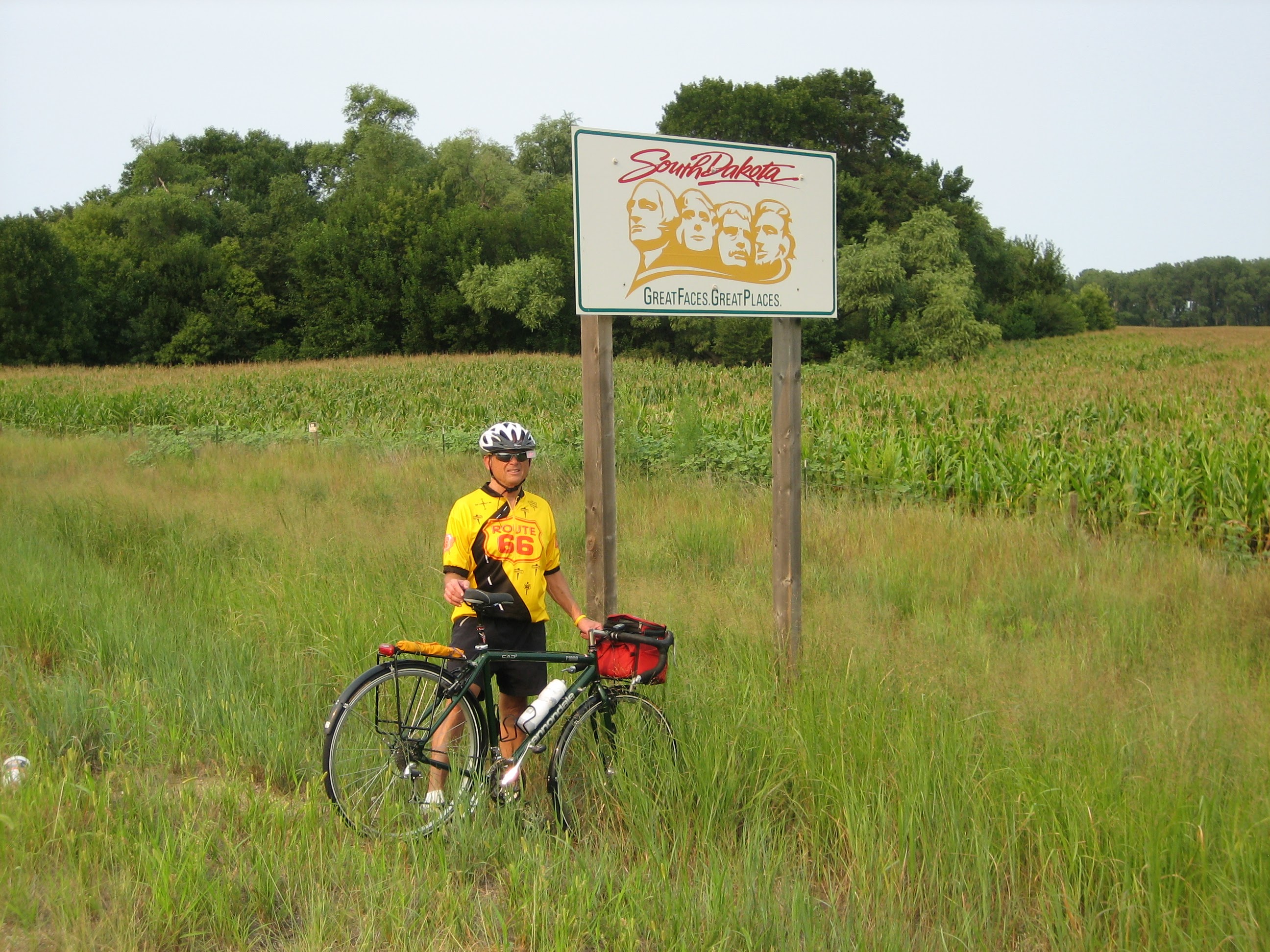 Tom or his touring bicycle photographed at the South Dakota state line or state landmark.
