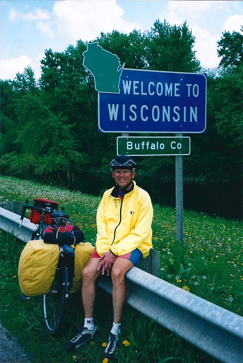 Tom or his touring bicycle photographed at the Wisconsin state line or state landmark.