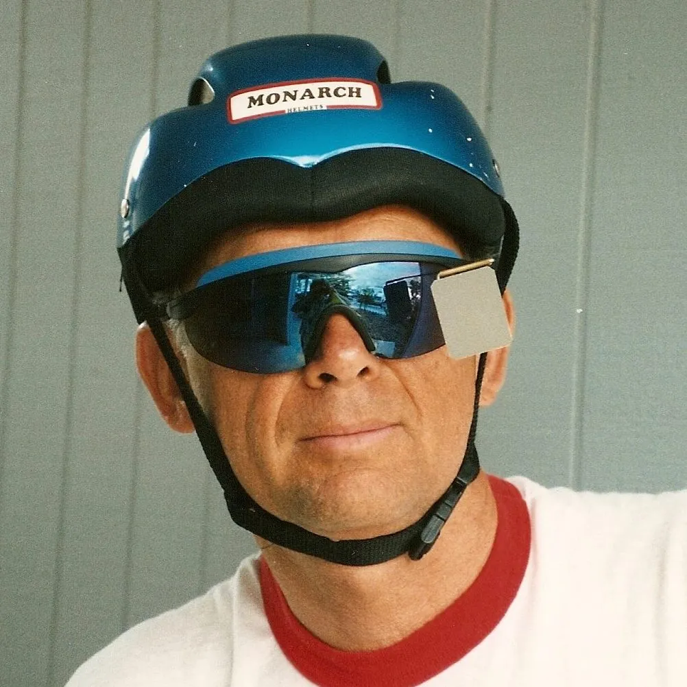 Tom O’Brien wearing a bicycle helmet and sunglasses